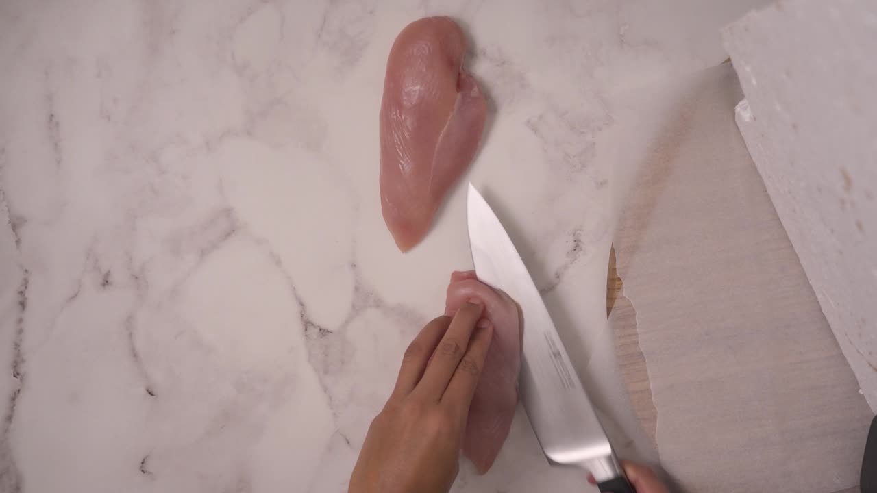 cortar pechos de pollo abiertos con un cuchillo de chef