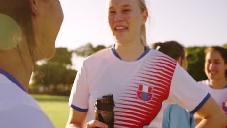 female soccer team in break time talking on soccer field. 4k