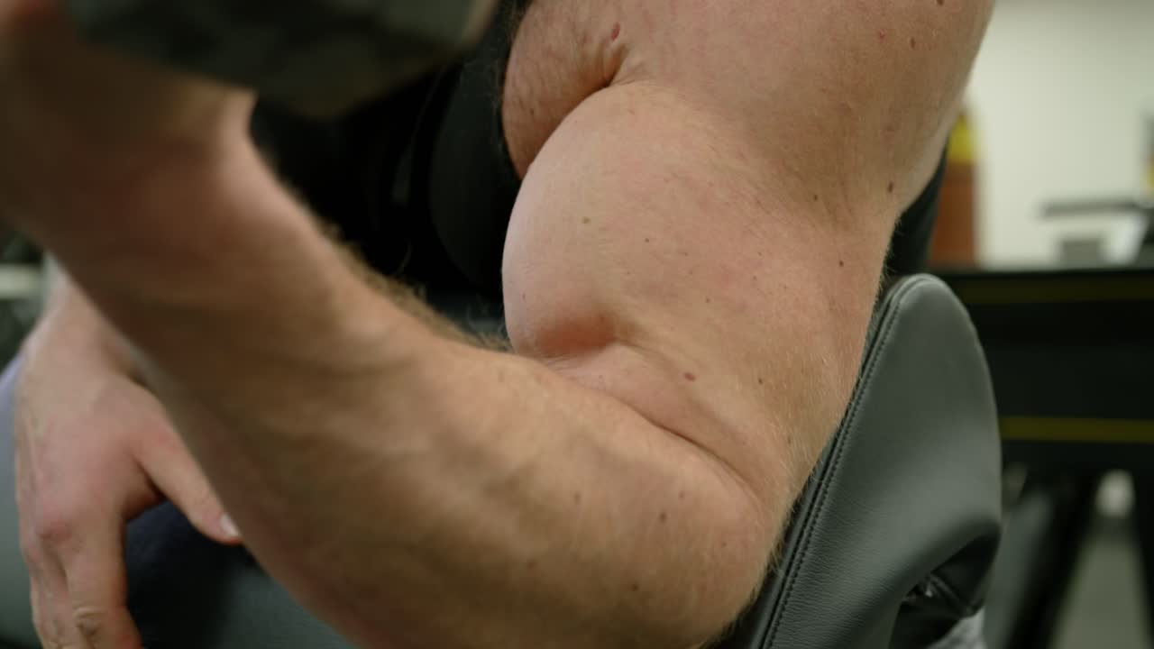 Young Adult Man Strenuously Working Out at Gym