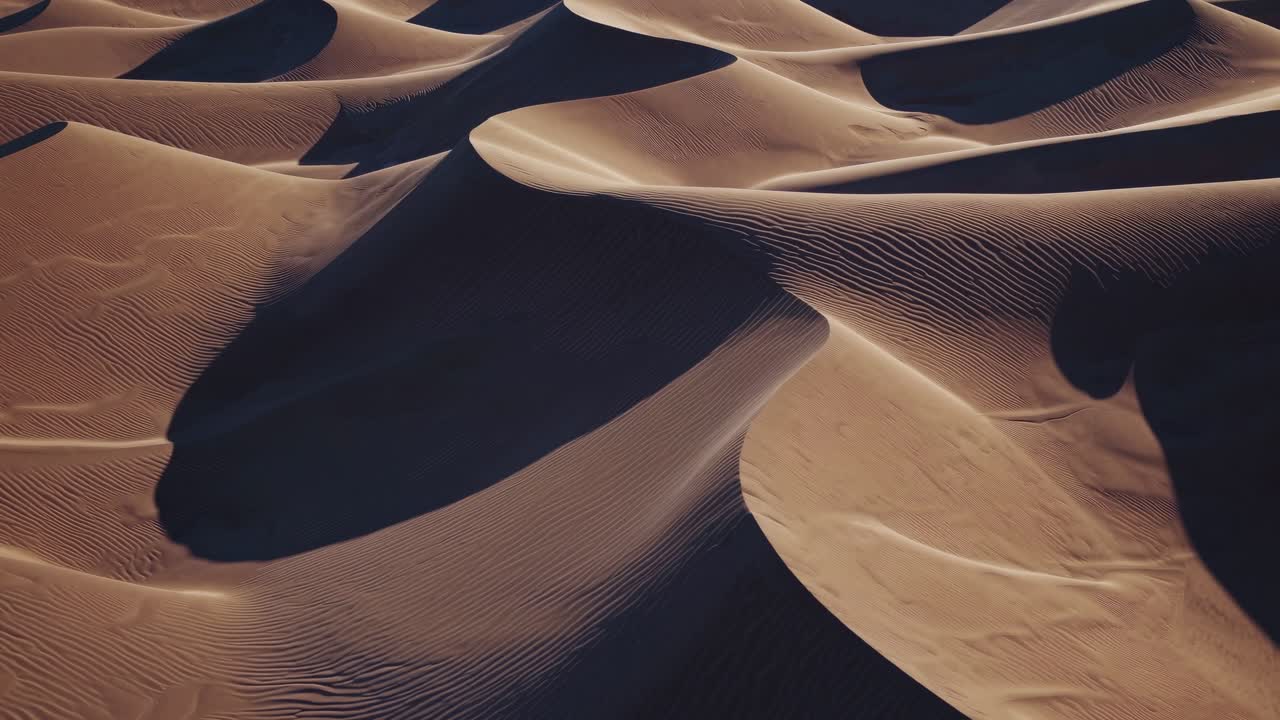 Vista aerea di dune di sabbia del deserto con increspature e ombre