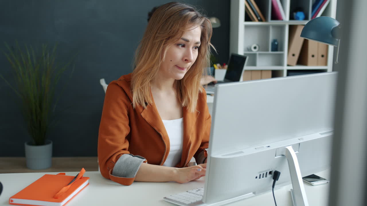 Женщина работает за компьютером, напряженное выражение лица