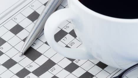 animación de crucigramas, bolígrafo, vasos y taza de café