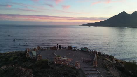 Adult-Women-Watching-Sunset-at-Viewpoint-in-Cabo-de-Gata,-Andalusia,-Spain---Aerial-4k