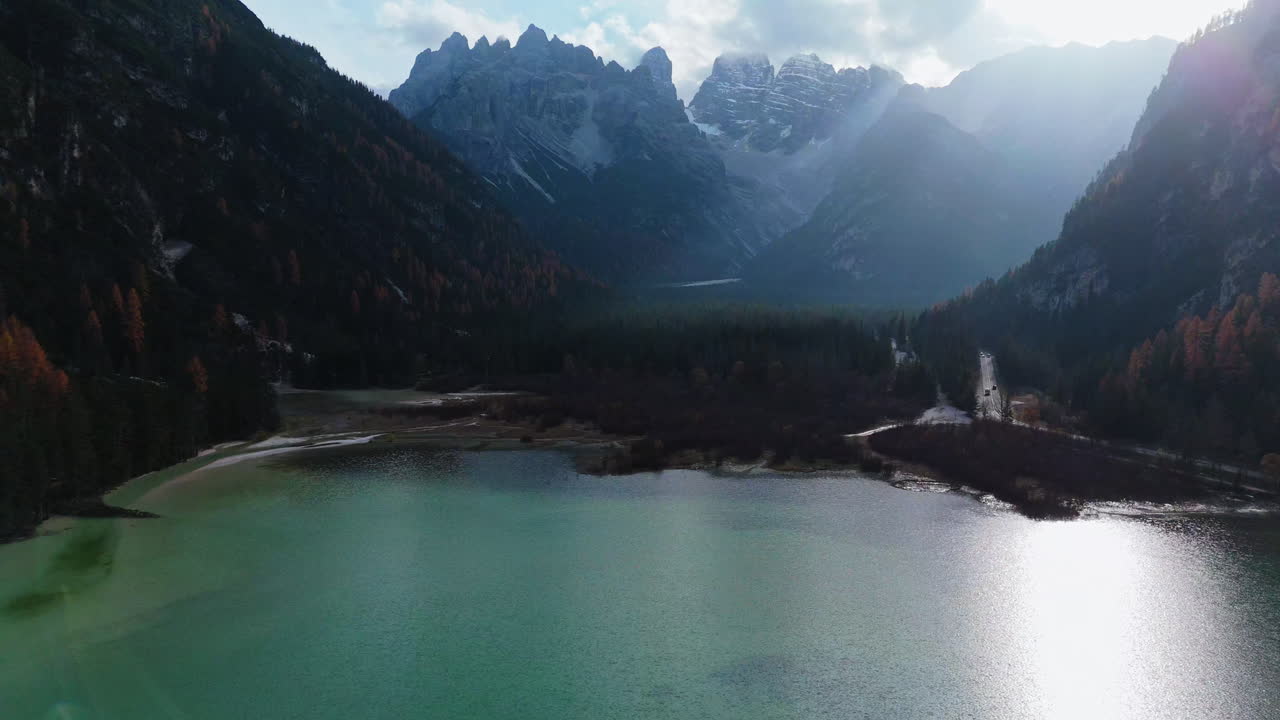 Serene Landro Lake with turquoise water surrounded by autumn trees and rugged mountains