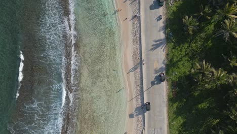 aerial view ocean waves and road next to caribbean beach