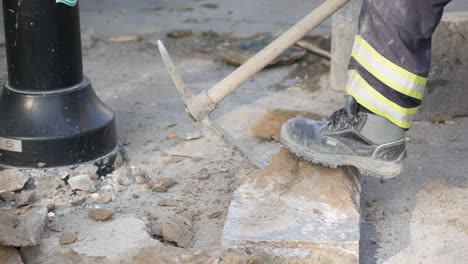 construction worker using pickaxe for demolition