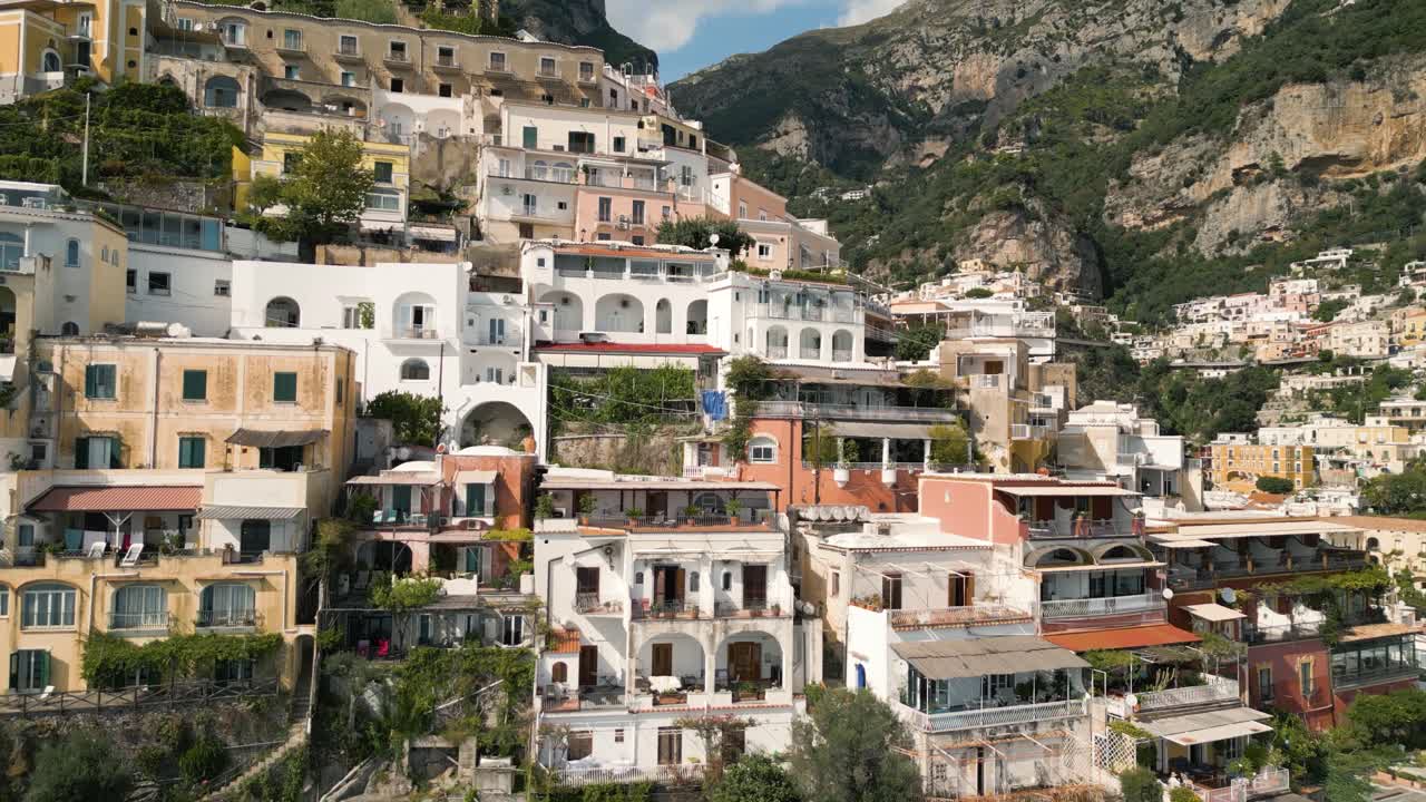 A 4k drone shot of Positano, Italy, showcasing its iconic cliffside architecture, colorful Mediterranean buildings, lush greenery, and breathtaking Amalfi Coast scenery.