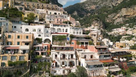 a 4k drone shot of positano, italy, showcasing its iconic cliffside architecture, colorful mediterranean buildings, lush greenery, and breathtaking amalfi coast scenery.