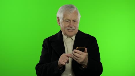 Elderly-stylish-caucasian-grandfather-man-using-social-media-app-on-smartphone