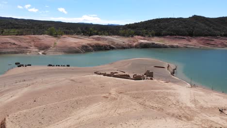 Empty-reservoir-with-ruined-houses.-Aerial-shot