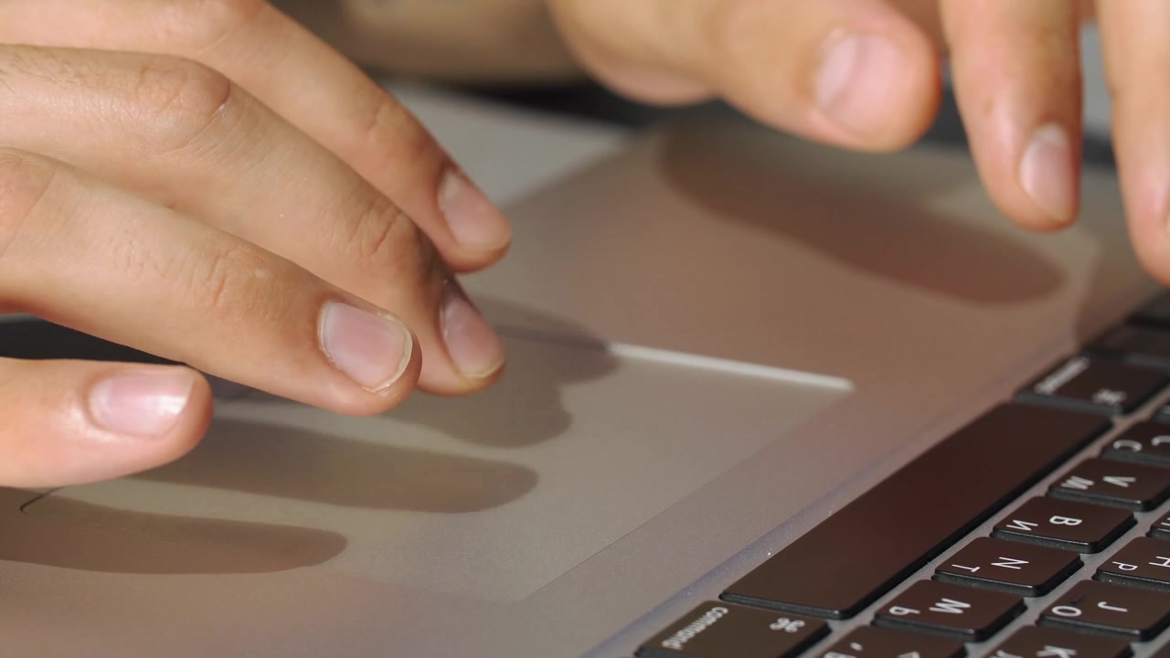 Primer plano de persona usando el trackpad de un portátil
