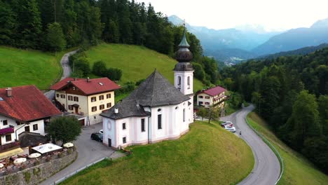 Aerial-orbit-around-Maria-Gern-chapel-upon-grassy-hill-on-overcast-day