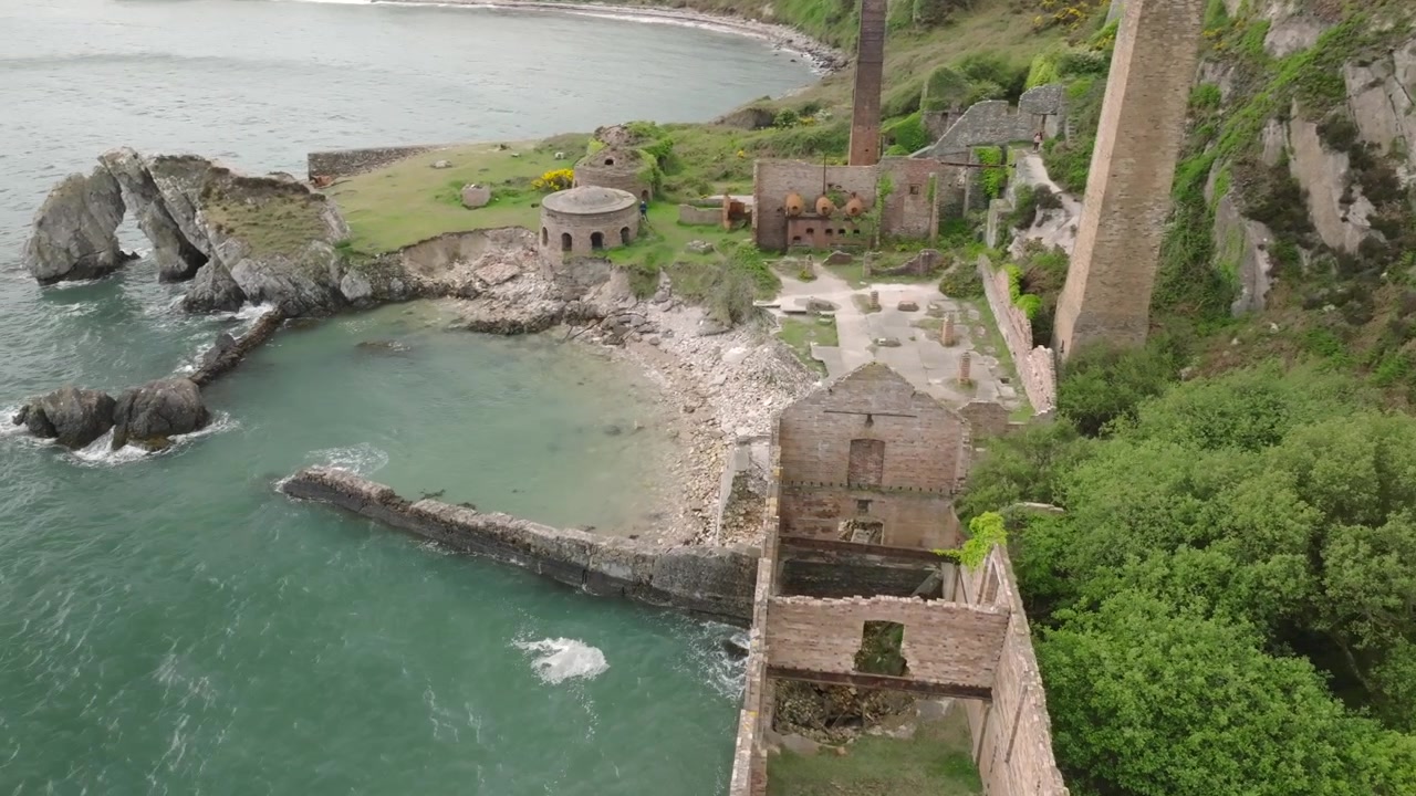 Fornaci di mattoni di Porth Wen, Anglesey, Galles. Orbita lenta che rivela un più ampio sito industriale abbandonato della rivoluzione industriale, inclusi forni a cupola e ciminiere quadrate.