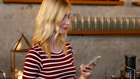 mujer joven usando su teléfono móvil mientras sostiene un vaso de champán en su mano 4k 4k