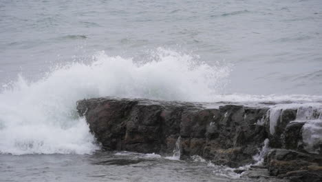 slow motion waves hitting rock