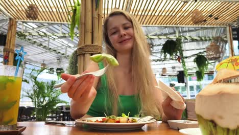 woman eating a salad in a tropical restaurant