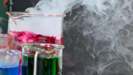 a mesmerizing display of colorful liquids and swirling smoke in laboratory beakers.