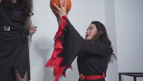 two witches holding a pumpkin