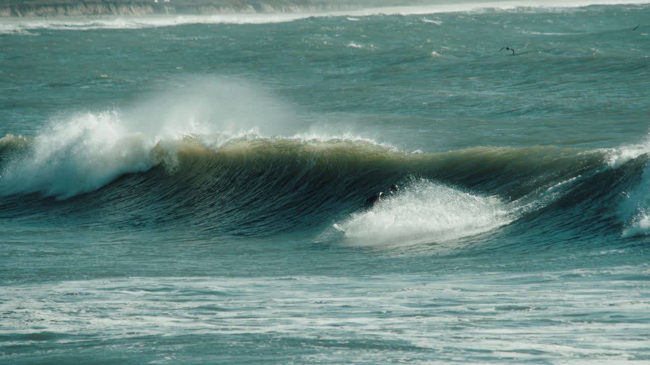 un surfista montando una ola en half moon bay, california, cerca de mavericks