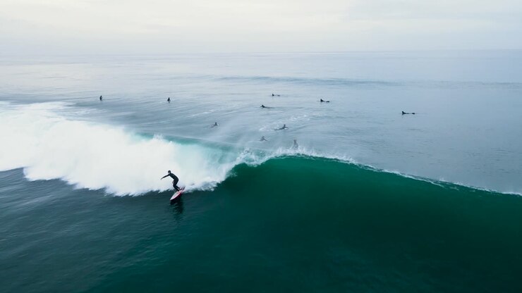 Aerial view of an unrecognizable surfer catching a wave in Carlsbad