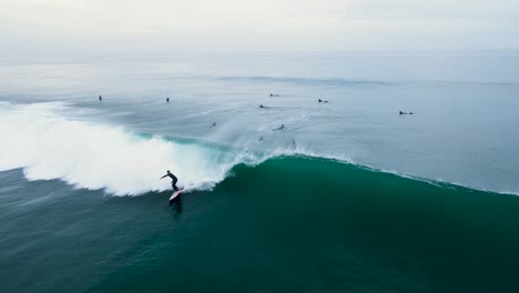 Aerial-view-of-an-unrecognizable-surfer-catching-a-wave-in-Carlsbad