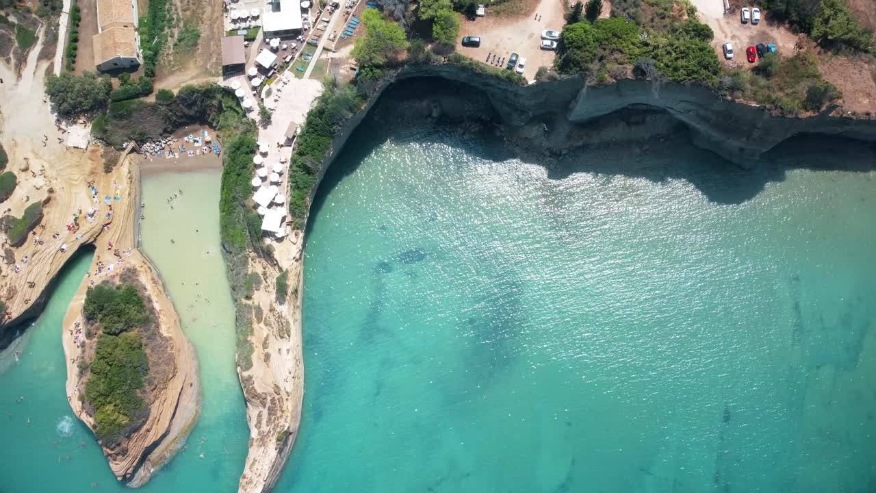 formación rocosa de acantilados con turistas tomando el sol en la impresionante playa europea de la isla de corfú, destino de vacaciones