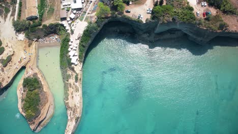 cliff rock formation with tourist sunbathing in stunning european beach corfu island travel holiday destination