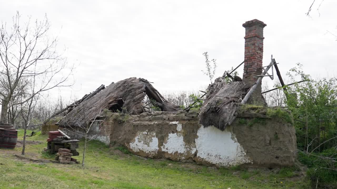 Rural cottage with collapsed thatched roof and damaged walls