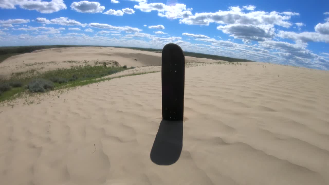 Skateboard deck standing in the sand in the sand dunes on a sunny day near Alberta Canada