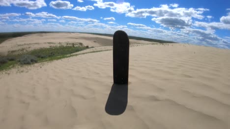 skateboard deck standing in the sand in the sand dunes on a sunny day near alberta canada
