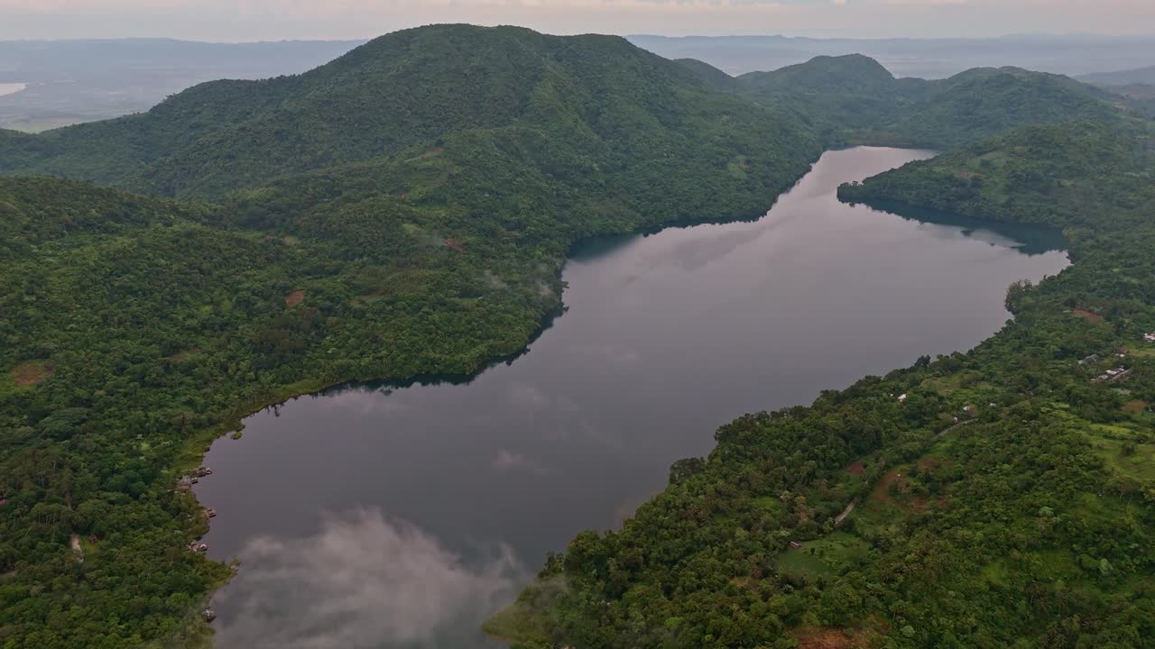 Drone glides over Lake Danao in Ormoc, Leyte, showing calm water and cloud reflections.