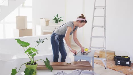 portrait of a caucasian woman in quarantine during coronavirus pandemic, doing interior work