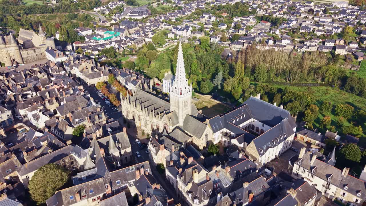 Vista aérea con dron de la histórica iglesia gótica de Notre Dame rodeada por los tejados del casco antiguo en Vitré, Bretaña, Francia