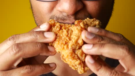 person eating a piece of fried chicken