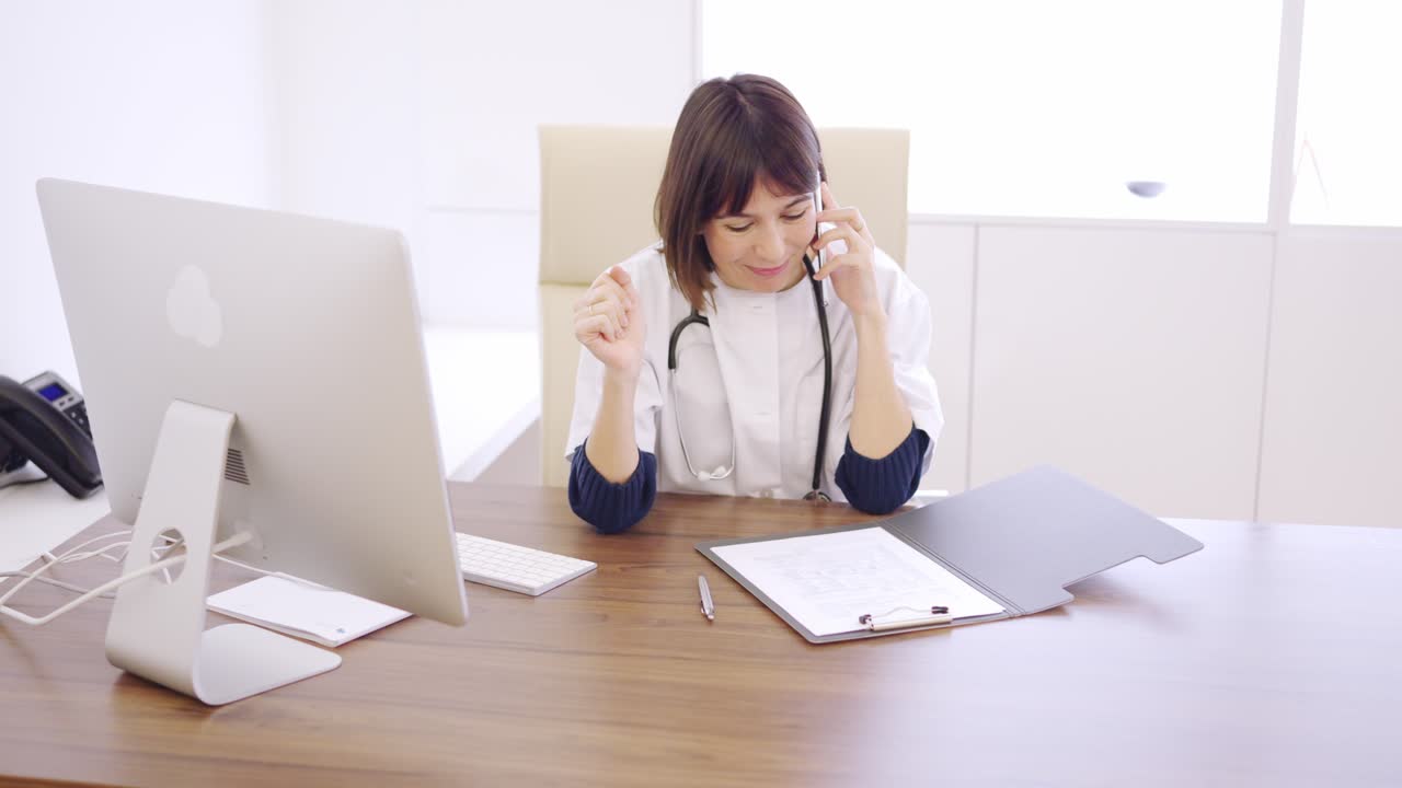 Doctor speaking on the phone celebrating a successful procedure