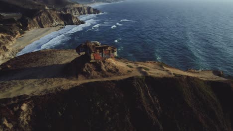 Cinematic-drone-shot-of-a-WWII-bunker-atop-a-cliff-overlooking-the-Pacific-Ocean-in-Northern-California