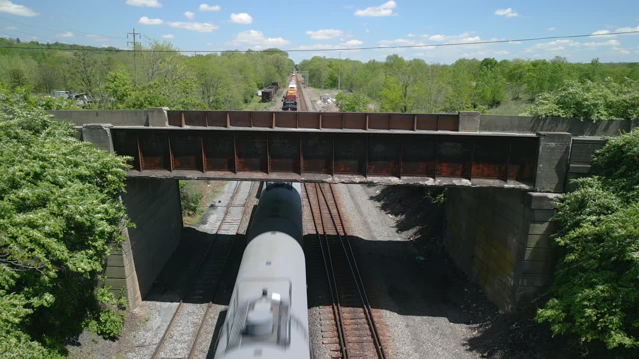 Aerial drone view of a bridge going over a railroad.