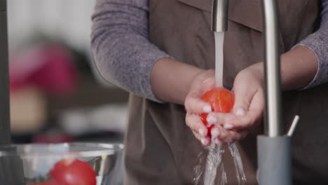 Eine-Frau-Wäscht-Tomaten-Unter-Einem-Wasserstrahl-Aus-Einem-Wasserhahn