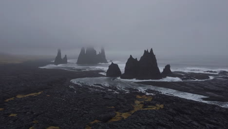 dramatic sea stacks on a misty volcanic coast