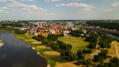 tomada de avión no tripulado del casco antiguo de kaunas con el castillo de kaunas, iglesias y otras casas antiguas de techo rojo entre los ríos nemunas y neris en kaunas, lituania en un soleado día de verano, acercándose