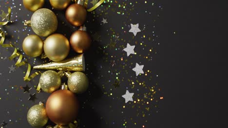 video de serpentinas de oro, conos de fiesta y bolas con brillo y estrellas de plata en negro