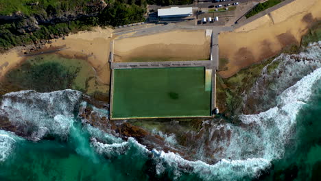 Rising-drone-shot-of-ocean-bathes-at-Merewether,-New-South-Wales