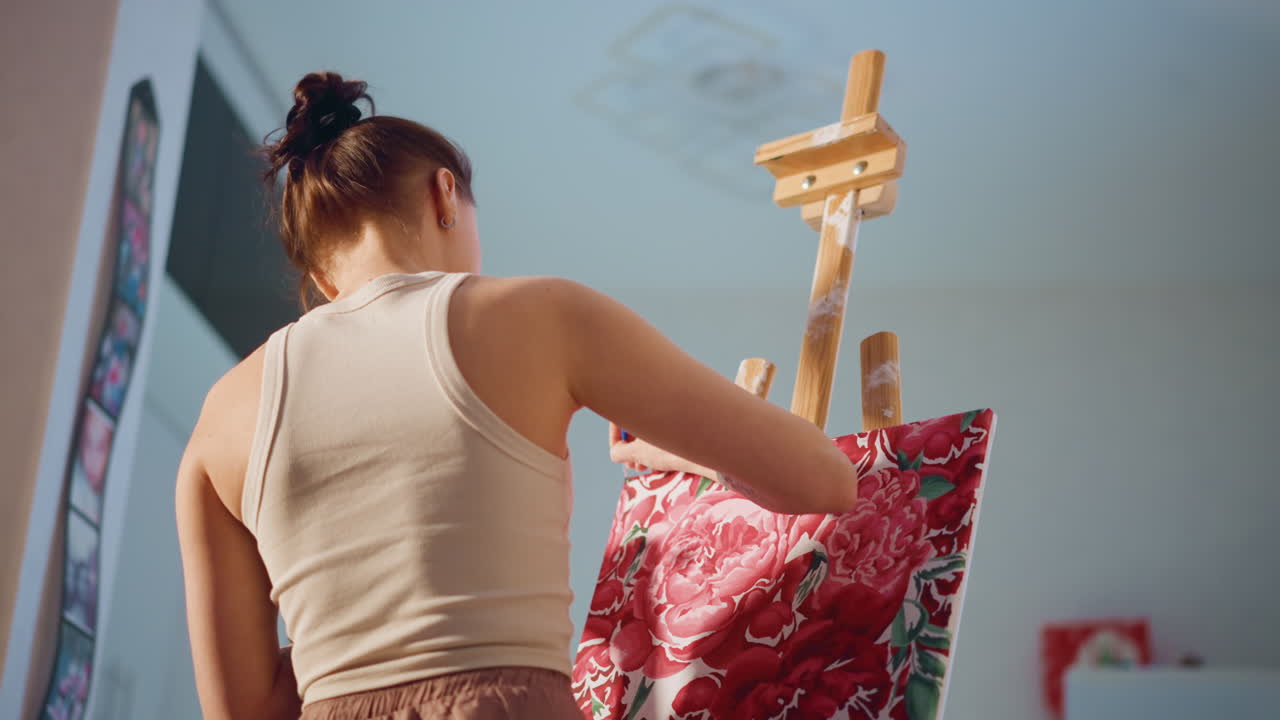 Caucasian Artist Inspects Floral Design On Canvas Meticulously, Painter Of European Descent Carefully Examines And Adjusts Floral Pattern On Canvas Amidst Natural Lighting Conditions
