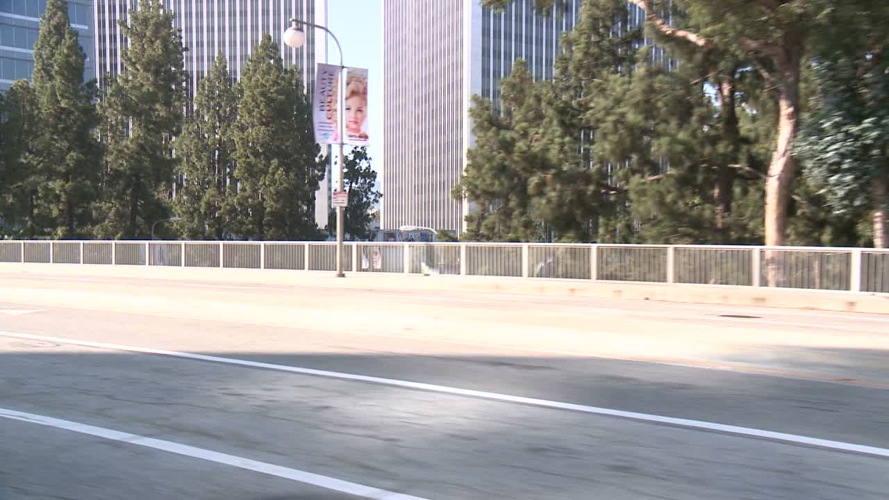 각도 2에서 후면 창을 통해 볼 때 자동차는 세기 도시 로스 앤젤레스에서 거리를 따라 여행