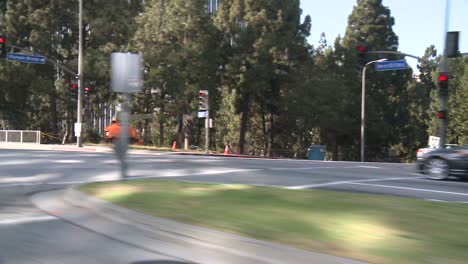 un automóvil viaja a lo largo de una calle en la ciudad del siglo de los ángeles, visto a través de la ventana trasera en un ángulo 2