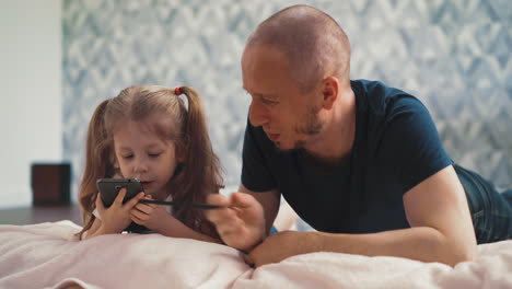 Linda-Niña-Y-Papá-Hacen-La-Tarea-En-Línea-Con-El-Teléfono