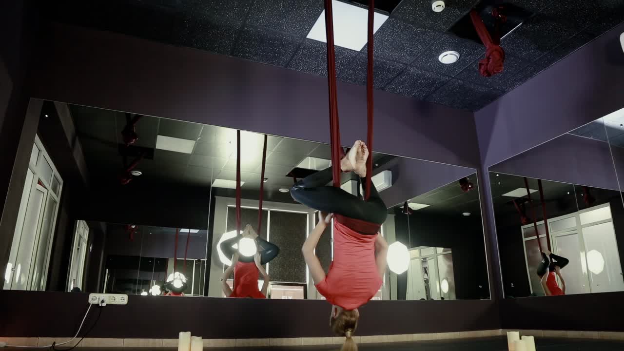 Girl on the ropes is engaged in yoga