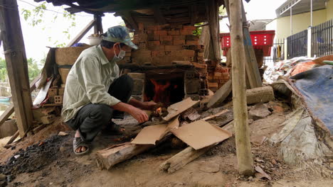 man starts raging fire in pottery kiln with cardboard and lighter, than ha hoi an vietnam