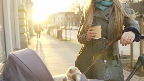 Mother-enjoys-hot-cup-of-coffee-on-a-cold-autumn-morning