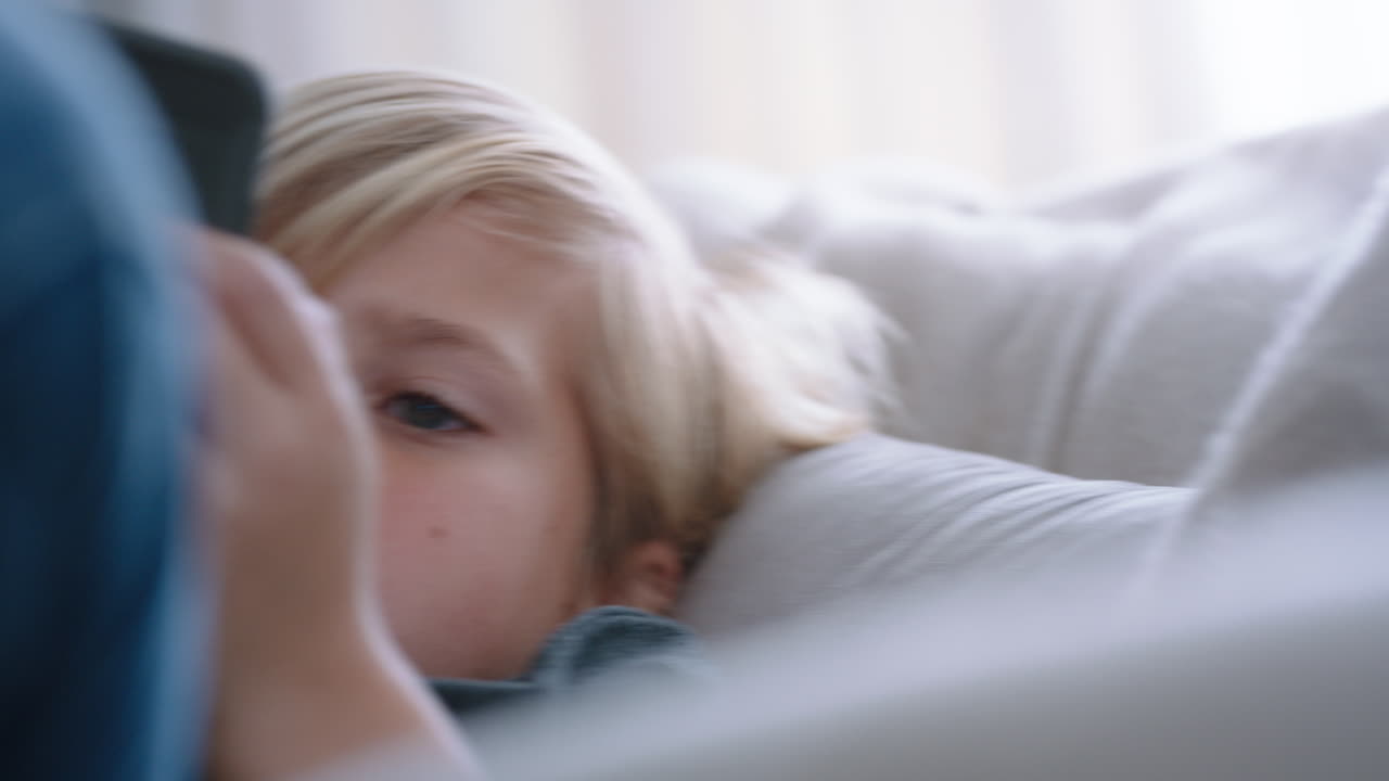 행복한 작은 소년은 스마트폰을 사용하여 게임을 즐기고 집에서 소파에서 휴식을 취하고 휴대 전화 기술로 온라인을 탐색하는 어린이 사회 중독 방지 개념 4k 영상